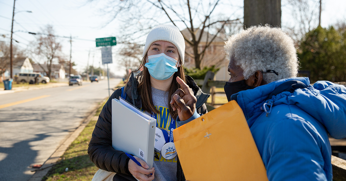 A student in the epidemiology program and a community volunteer conduct a COVID-19 survey, wearing masks, in New Castle.