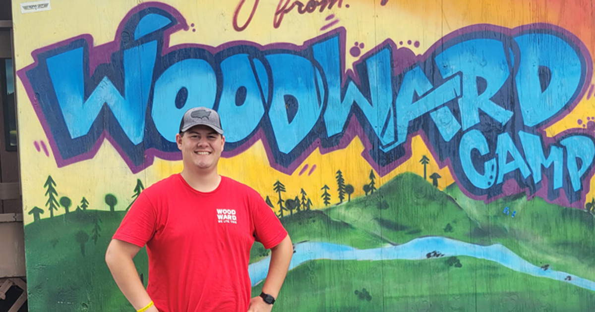 Dylan Morgan poses outside a colorful graffiti-style sign that reads Camp Woodward. Morgan, a second-year athletic training master's student interned at the extreme sports summer camp in California and Pennsylvania this past summer.