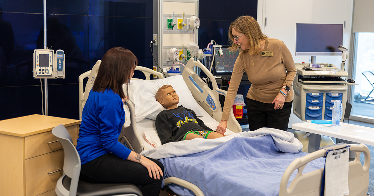 Attendees of CHS Teaching Day are checking the pulse on a high-fidelity mannequin as they take part in a workshop on simulation as a teaching strategy to improve learning outcomes.