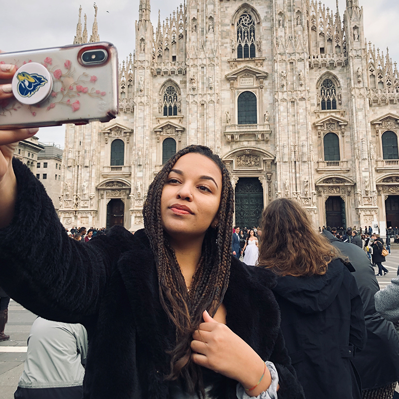 A photo of a student taking a selfie in front of an Italian landmark.