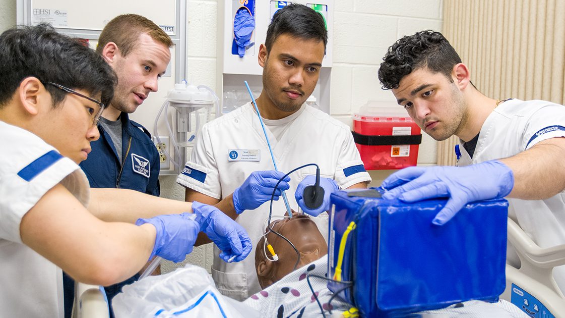 Students practice on a medical dummy at UD. 