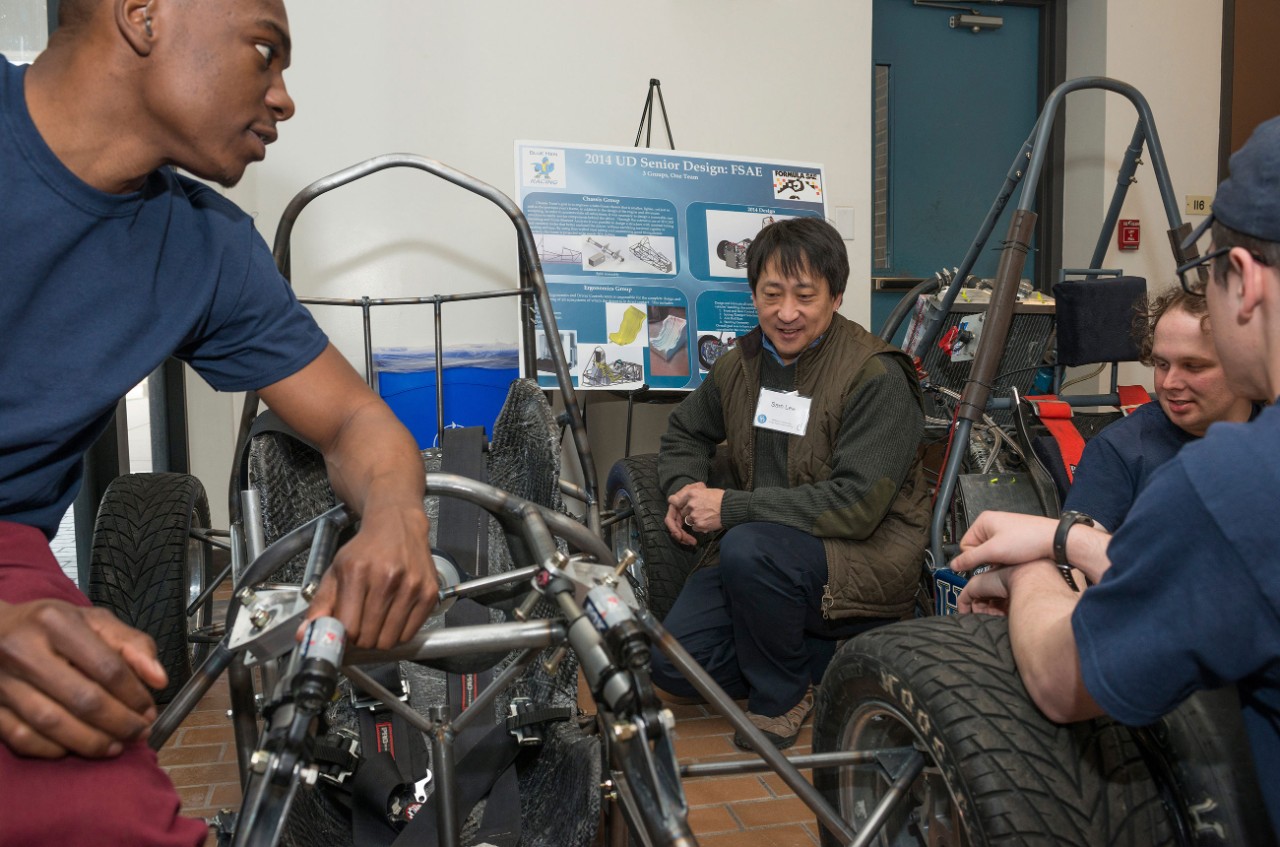 Four UD researchers work together on a one-man vehicle. 