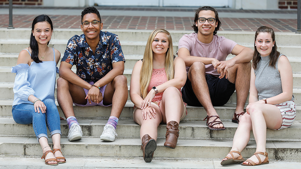5 university of delaware students in the lerner college of business and economics sitting on the steps outside a classroom building