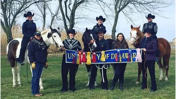 Equestrian team group photo with horses and students