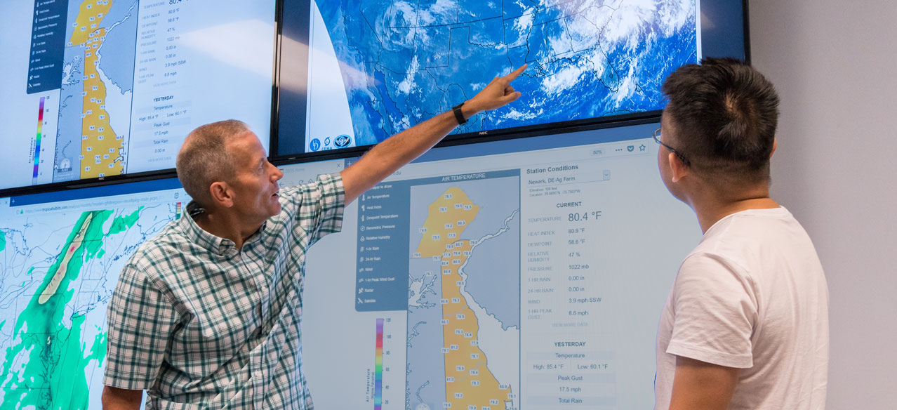 professor and student at the University of Delaware working in the meteorology visualization lab in Pearson hall
