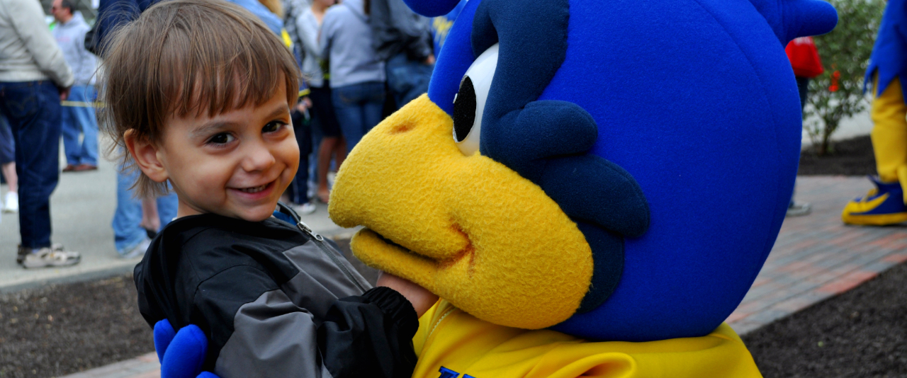 Smiling boy with University of Delaware mascot YouDee