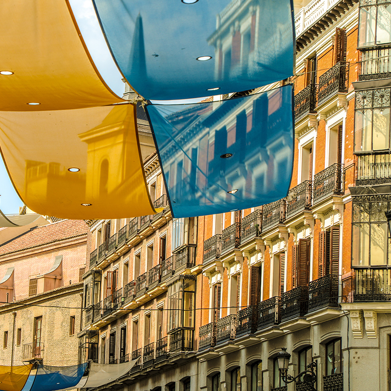 A view of blue and gold flags hanging from the street in the Plaza del Sol, Madrid. 