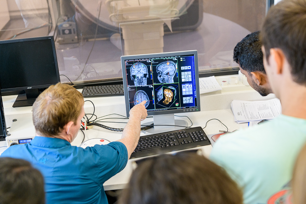 Students participating in the department's Summer Workshop in Cognitive and Brain Sciences (Brain Camp) study and draw conclusions from readings provided by the university's fMRI scanner while visiting the UD Center for Biomedical and Brain Imaging.