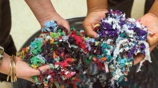 Hands holding recycled textile waste.