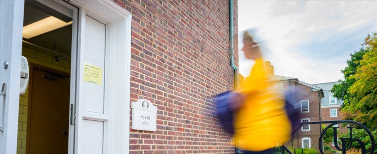 blurred image of a student walking into Smyth Hall