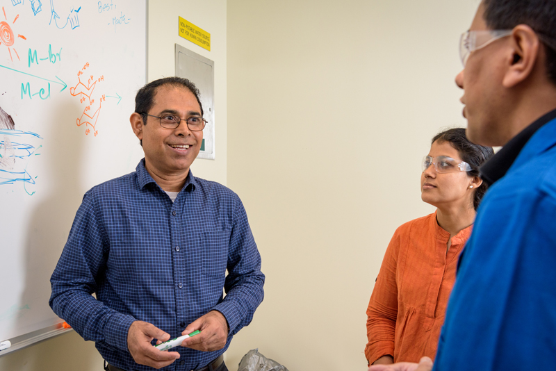 Basudeb Saha, the associate director of research for the Catalysis Center for Energy Innovation, speaking with colleagues Sunitha Sadula and Saikat Dutta.