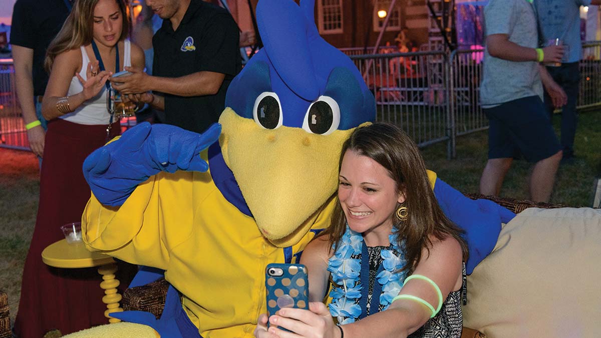 A woman takes a selfie with YouDee at an University of Delaware event.