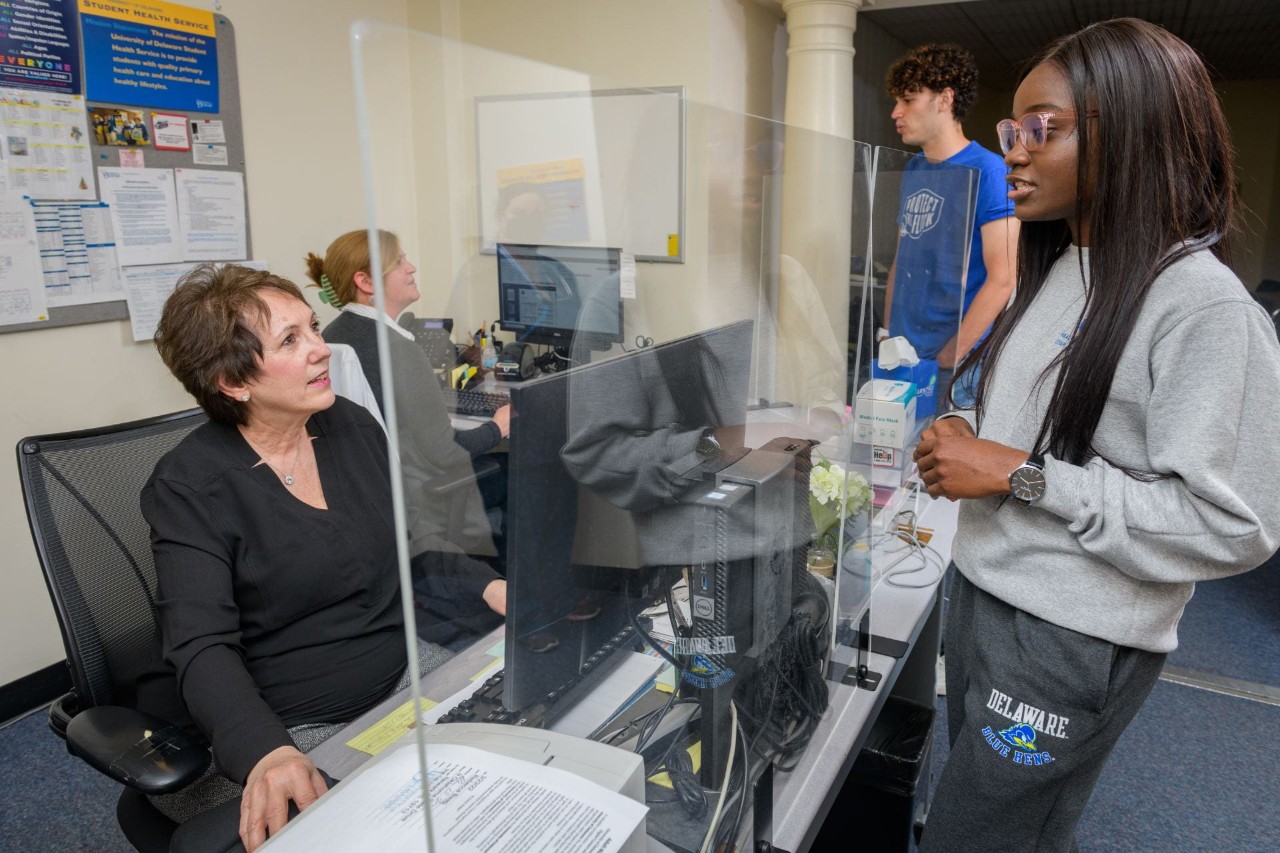 Two students consult with staff in Student Health Services