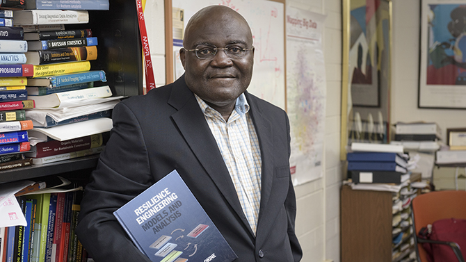 Nii O. Attoh-Okine, professor of Civil and Environmental Engineering, with a copy of his newly published book “Resilience Engineering: Models and Analysis.” - (Evan Krape / University of Delaware)