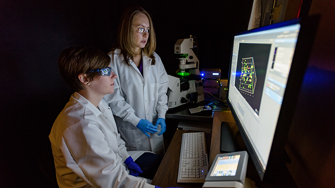 CHEG-Kloxin-Sawicki-Breast_Cancer_Research-093016 April Kloxin, assistant professor of Chemical and Biomolecular Engineering, with her student Lisa Sawicki in Colburn Lab looking at research samples. Klaxon and her group are recent recipients of a significant grant from the Susan G. Komen foundation for research into the growth of breast cancer cells. - (Evan Krape / University of Delaware)