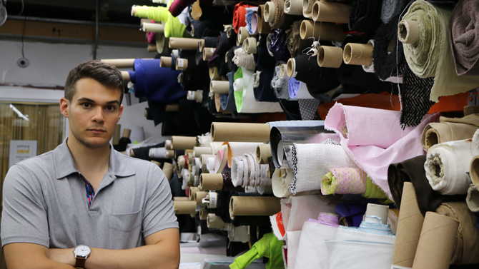UD’s first entrepreneurship major Jordan Sack. Included is a photo of Jordan Sack standing in a fabric warehouse in New York. Tillinger, a clothing company 