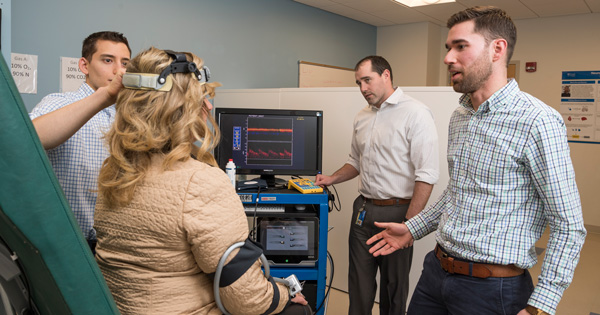 Researcher Christopher Martens (right) is investigating nicotinamide riboside’s impact on age-related diseases like mild cognitive disorder and dementia. In this photo, lab coordinator Joshua Hobson (center) runs the computer while graduate student Theodore DeConne (left) uses an ultrasound probe to measure brain blood flow.