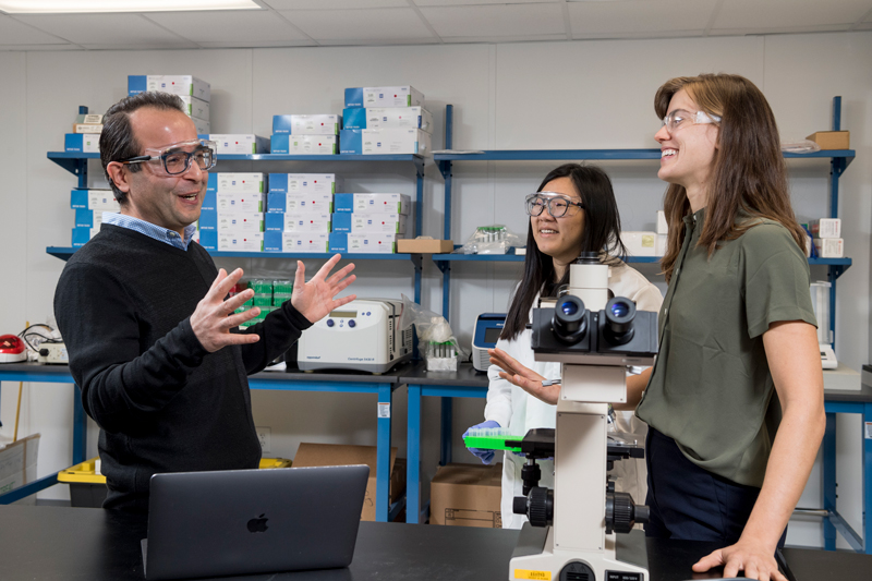 Professor Benham Abasht and his graduate students Juniper Lake (green shirt) and Ziqing Wang (lab coat) are working on Wooden Breast Disease - a genetic problem affecting chickens.