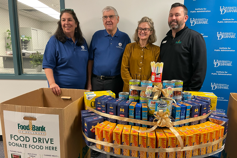 Biden School Dean Amy Ellen Schwartz and Lewis presented food drive donations to Food Bank of Delaware representatives Kim Turner, vice president of communications, and Trevor Turner, chief operating officer.