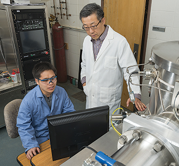 Prof. John Xiao (standing) and research associate Xin Fan conduct spintronics research. Xiao will co-direct ISE Lab’s nanofabrication facility.