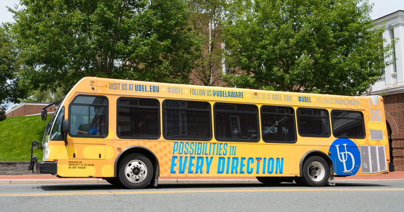 A UD transit bus wrapped in yellow