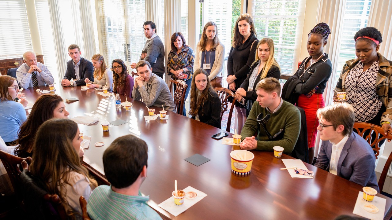 UD students sit around a table at the Biden Institute while visiting with President Joe Biden.