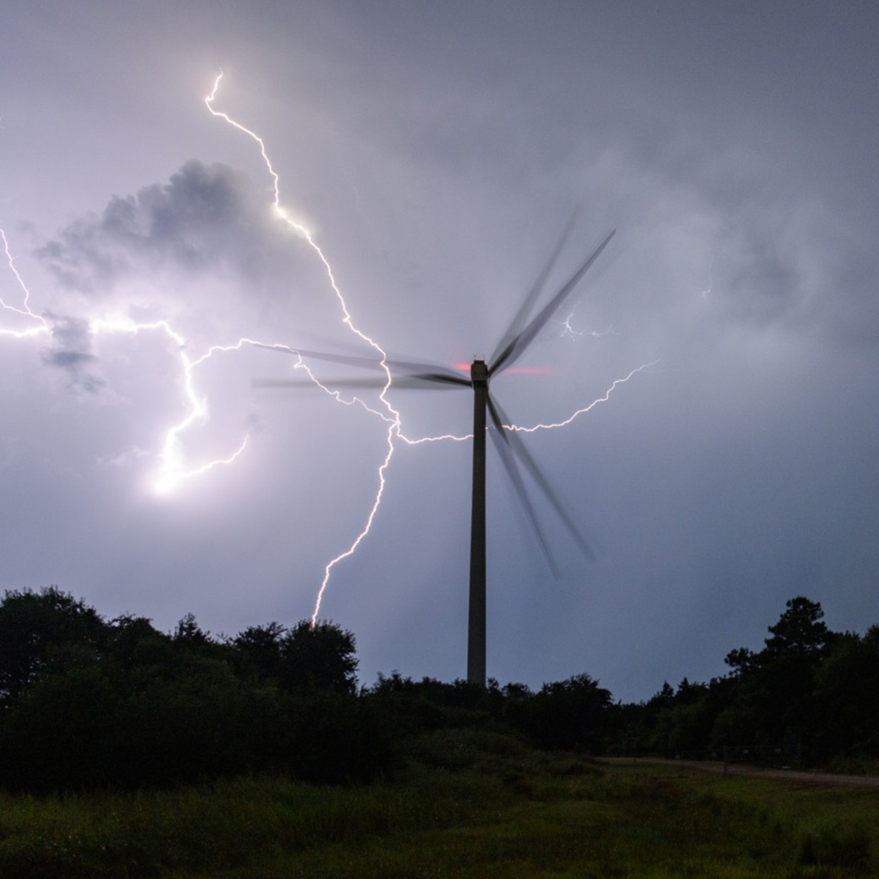 Photo of a wind turbine during a lighting storm