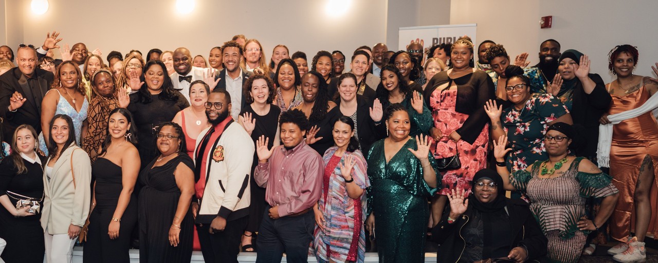 Large group photo of Public Allies Delaware alumni gathered together wearing formal attire at the 30th Anniversary Celebration in 2024