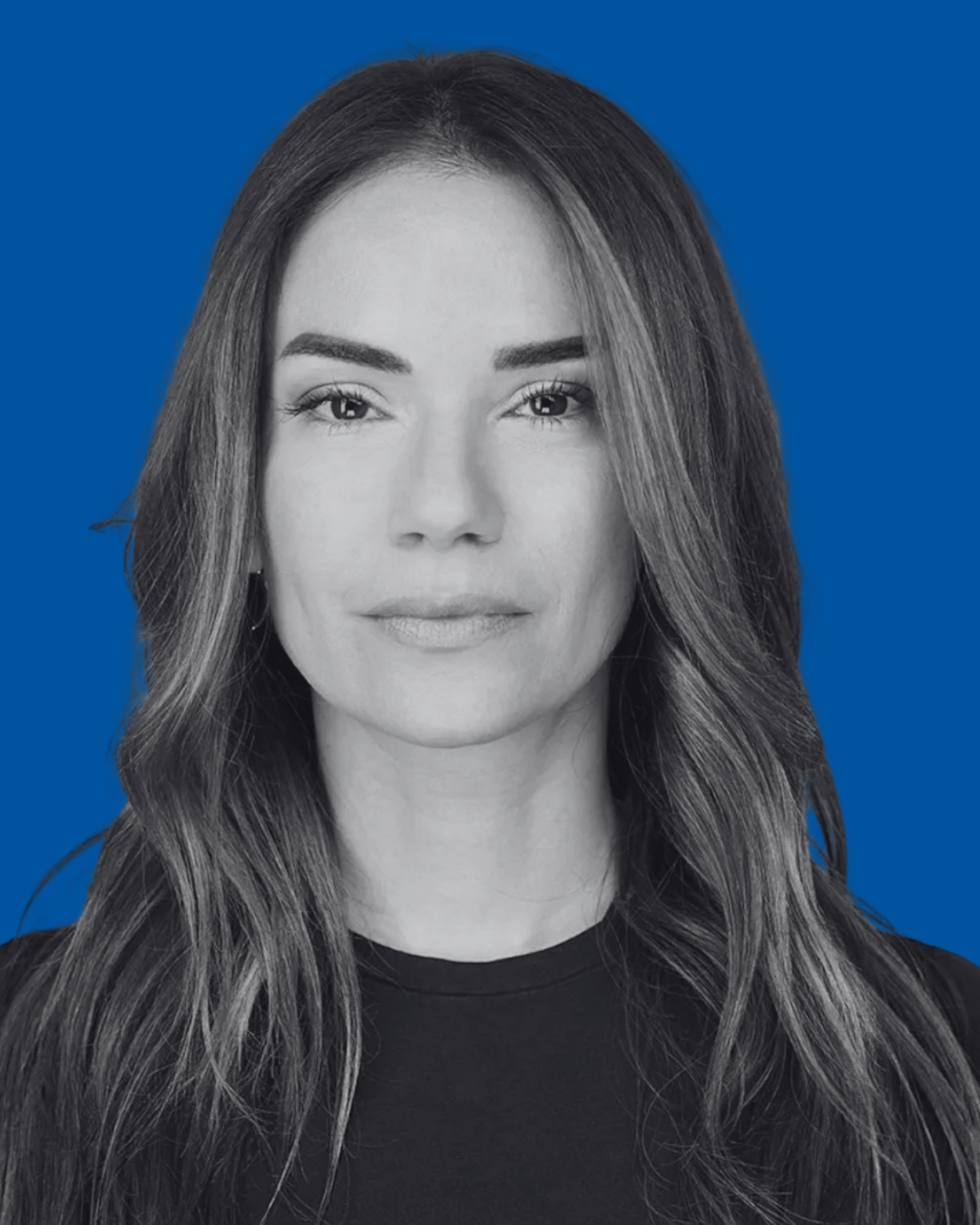 A black-and-white portrait of a person against a solid blue background
