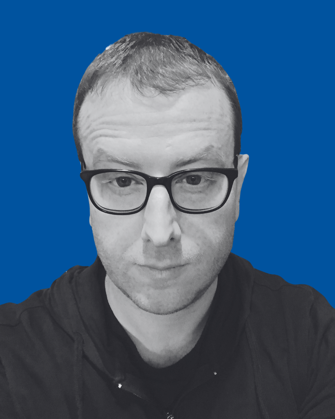A black-and-white portrait of a person against a solid blue background