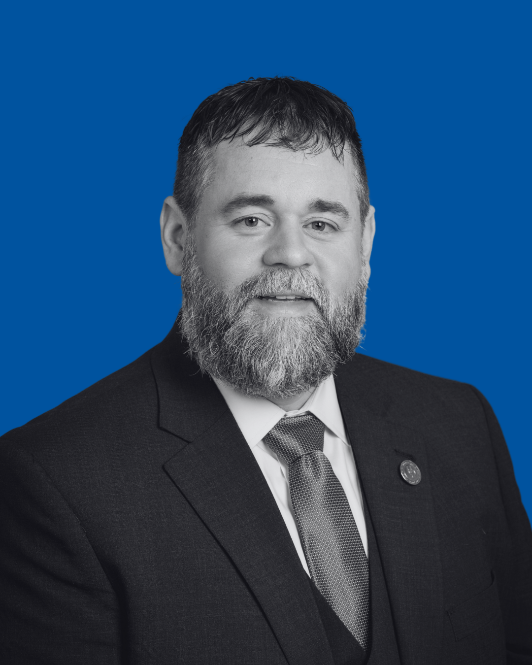 A black-and-white portrait of a person against a solid blue background