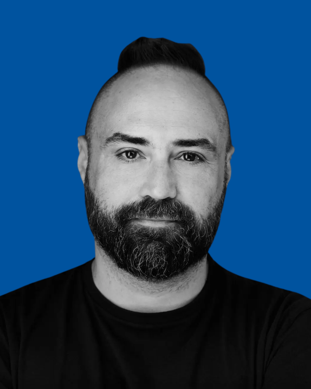A black-and-white portrait of a person against a solid blue background