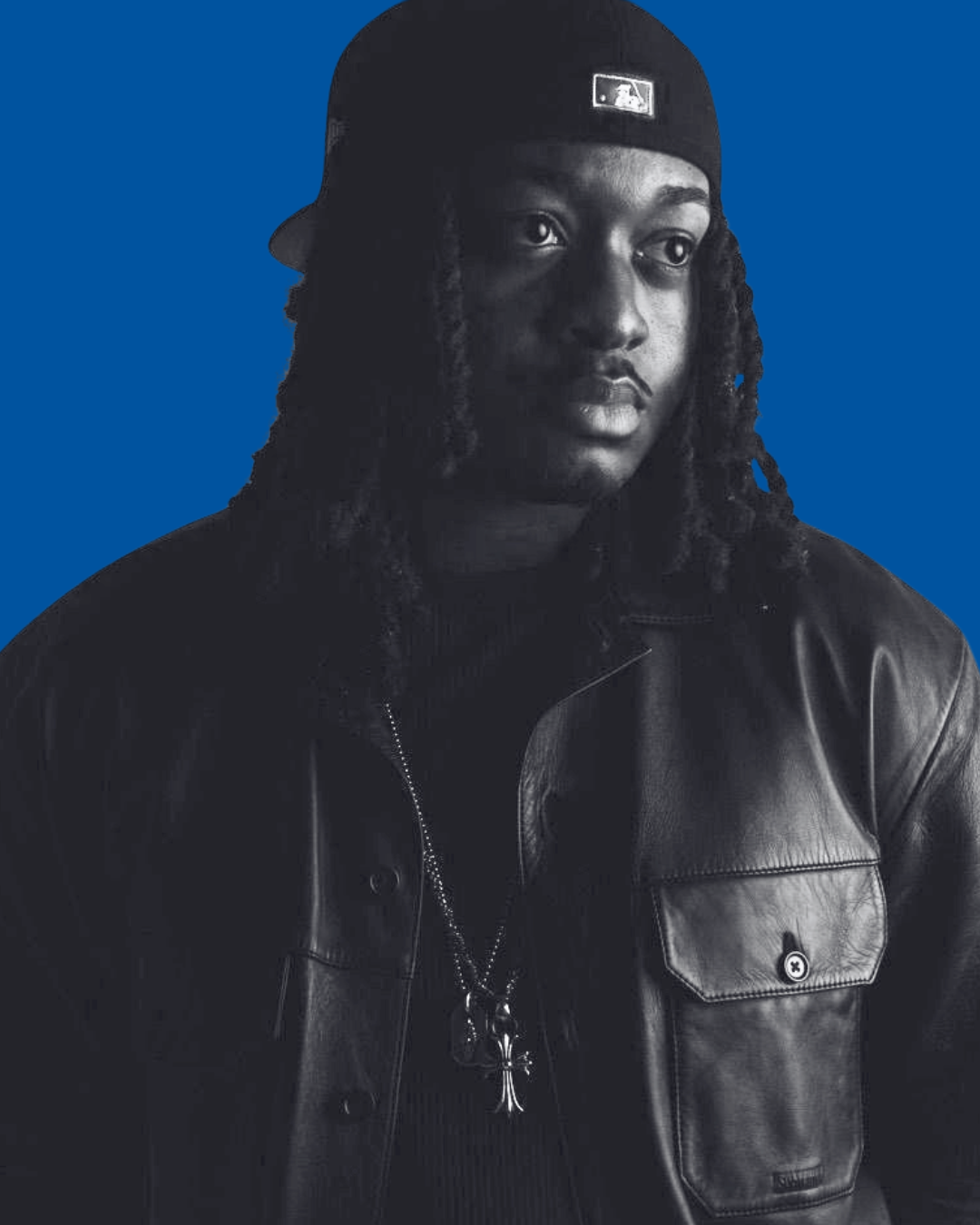 A black-and-white portrait of a person against a solid blue background