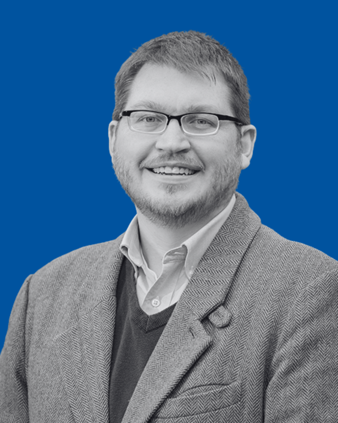 A black-and-white portrait of a person against a solid blue background
