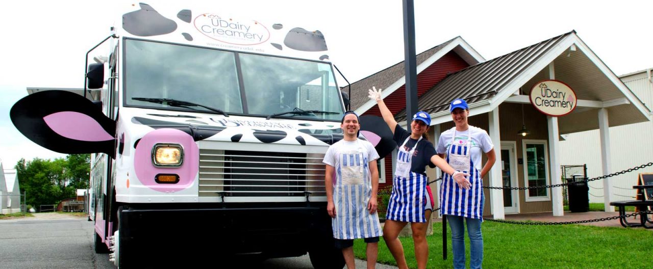 Front of the UDairy Creamery Moo Mobile with three student employees