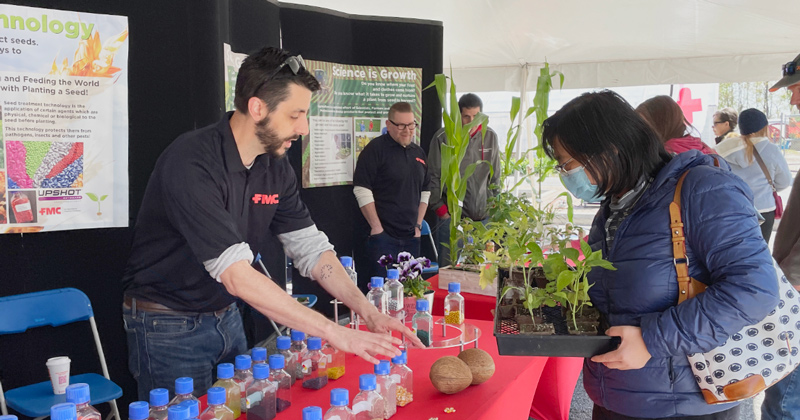 An alumni working a booth at Ag Day.