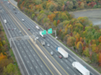 A highway with colorful treetops on the side