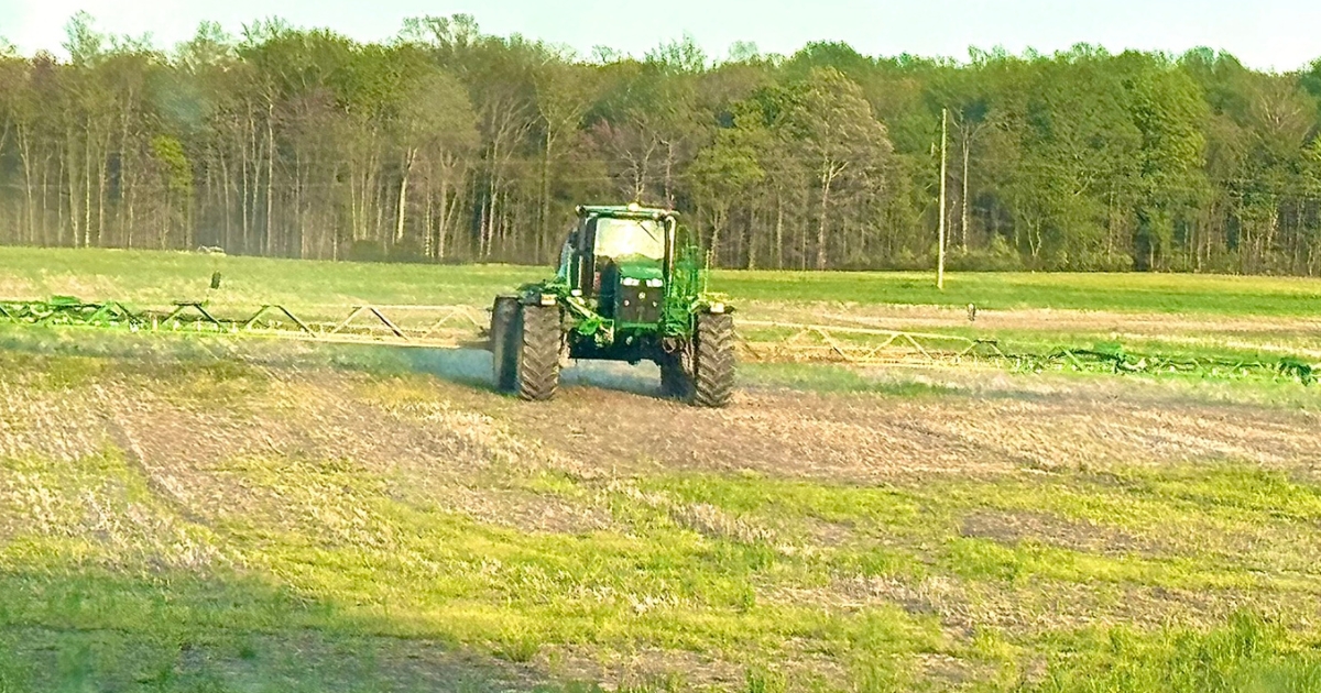 A tractor in a field applying lime