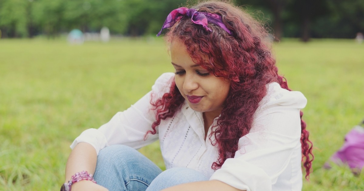 A woman enjoying time alone in a park.