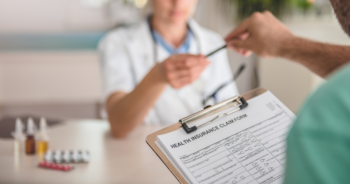 Person filling out an insurance form at the doctor's office.