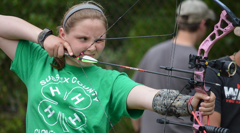 4-H member lines up her sights in an archery competition