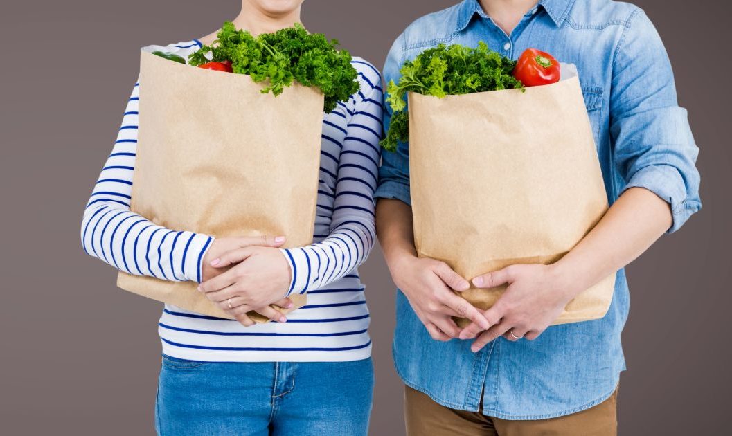 A man and woman holding grocery bags