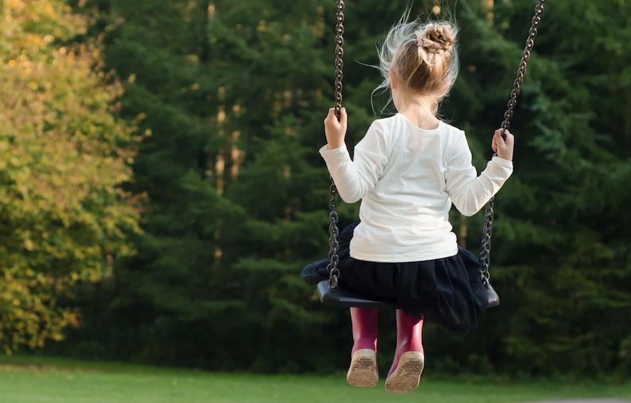 A child playing on a swing.