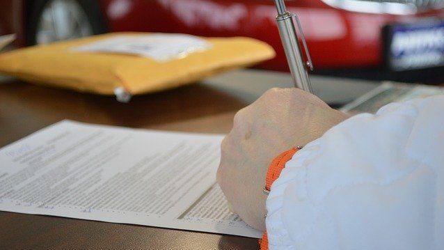 A person signing a loan document.
