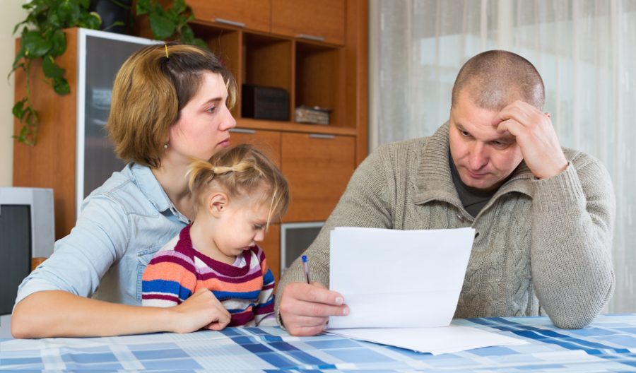 A family struggling with their budget at the kitchen table.