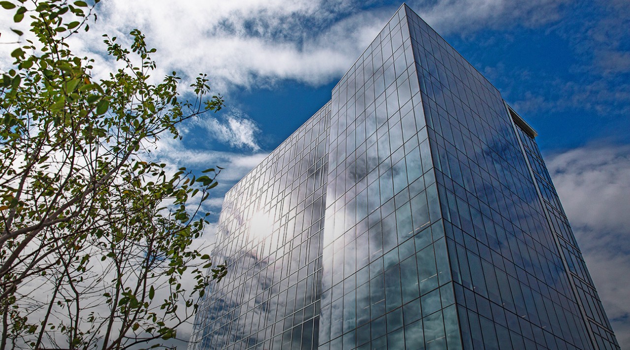 A tall windowed office building sits against a blue sky: the University of Delaware STAR Campus in Newark, Delaware