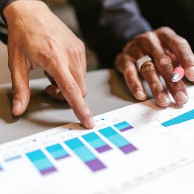 Two people analyzing data printed on sheets.