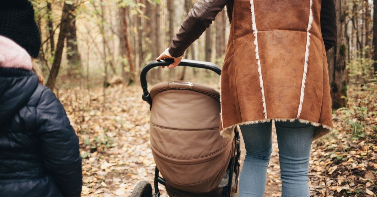 A young family walking in the woods.