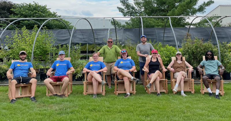 Sitting in Adirondack chairs. UD students and faculty sit in newly made Adirondack chairs.