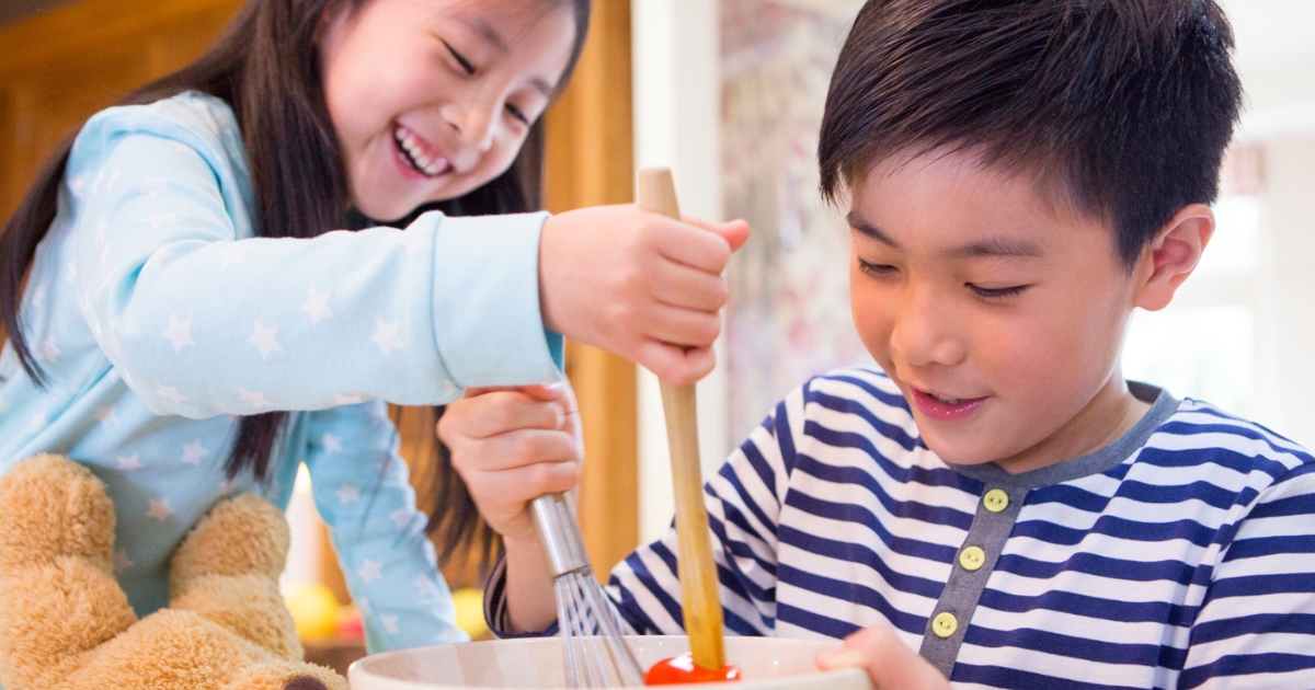 Two children stirring a bowl.